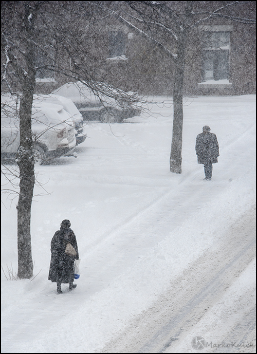 Meeting - I waited in my window and actively composed this scene last winter. There is a strong suggestion of story here because the person in the background appears to be waiting for the foreground woman. I clicked the shutter only when I felt the timing was right compositionally.